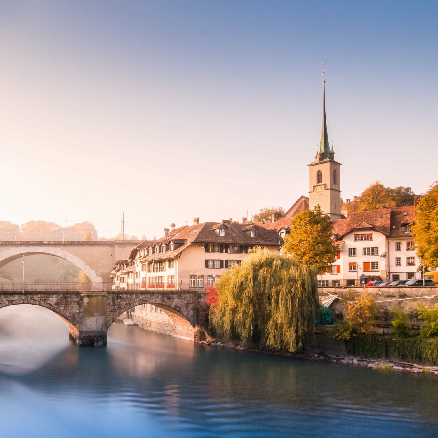 Old town of Bern, UNESCO, Switzerland with two bridges, river and church in early colorful autumn morning with soft light